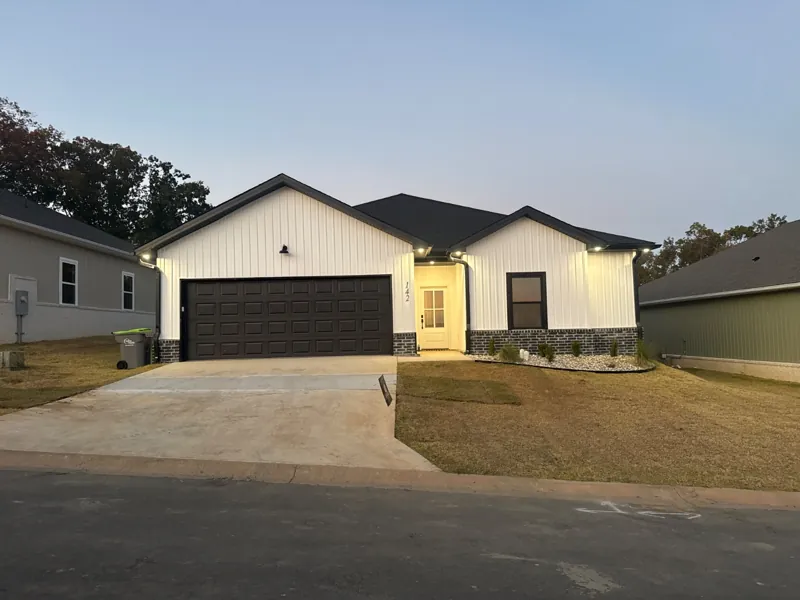 A white four-bedroom home in Mountain Falls Estates at dusk